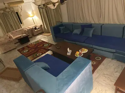a living room with a blue couch and a table at Paradise Villa Seaview in Hurghada
