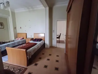 a bedroom with a bed and a desk in a room at Ahmeds in Luxor