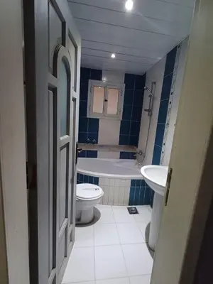 a bathroom with a tub and a toilet and a sink at Ahmeds in Luxor