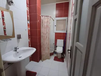 a bathroom with a white sink and a toilet at Ahmeds in Luxor