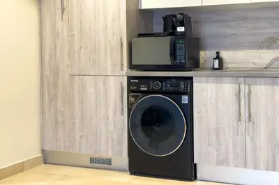 a microwave sitting on top of a washing machine in a kitchen at Neat & Neutral 1BDR Pool front Mangroovy in Hurghada