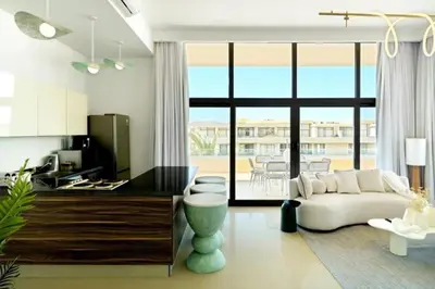 a living room with a white couch and a kitchen at Cozy getaway in El Gouna with pool & mountain view in Hurghada