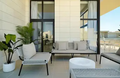 a patio with couches and chairs on a building at Cozy getaway in El Gouna with pool & mountain view in Hurghada
