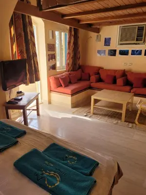 a living room with a red couch and a table at Charming Studio in Downtown El Gouna in Hurghada