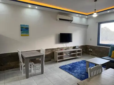 a living room with a table and a tv at Modern European Style apartment 1 in Hurghada