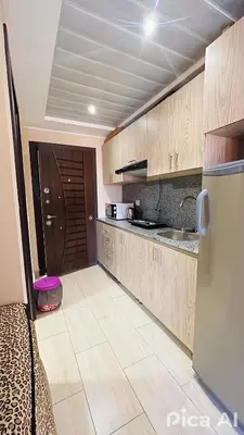 a kitchen with wooden cabinets and a refrigerator at Amazing Apartment Aldau Heights in Hurghada