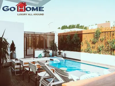 a magazine cover of a patio with a pool and chairs at El Gouna 3 Bedroom in Sholan in Hurghada
