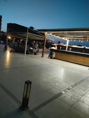 a rooftop patio with people sitting at tables at night at Scandic Resort in Hurghada