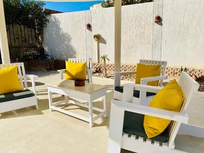 a group of chairs with yellow pillows on a patio at Magawish Hurghada Studio 7 in Hurghada