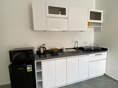 a kitchen with white cabinets and a black refrigerator at Magawish Hurghada Studio 7 in Hurghada