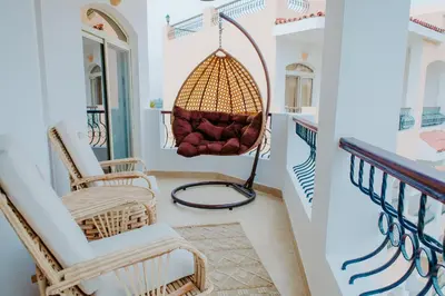 a room with two chairs and a hanging basket at Aton Suites Luxor Resort East Bank Nile View in Luxor