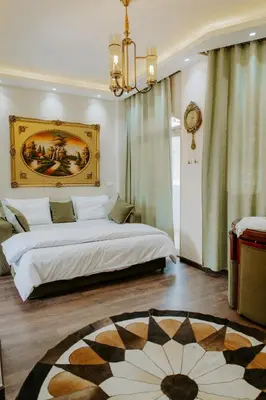 a bedroom with a bed with a painting on the wall at Aton Suites Luxor Resort East Bank Nile View in Luxor