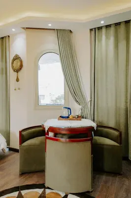 a room with two chairs and a table and a window at Aton Suites Luxor Resort East Bank Nile View in Luxor