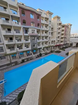 a swimming pool in front of a large apartment building at Florenza Khamsin in Hurghada