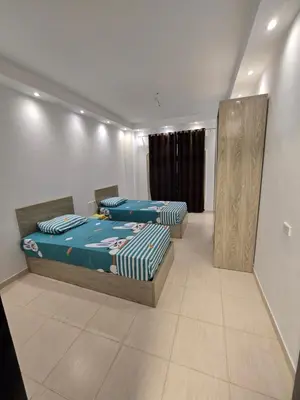 a room with two beds and a mirror in it at Florenza Khamsin in Hurghada