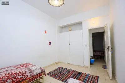 a white room with a bed and a hallway at Isis Club House in ‘Ezbet Abu Ḥabashi