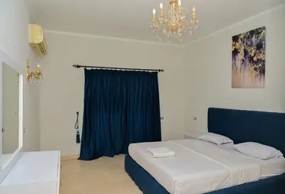 a bedroom with a large bed with a blue curtain at 6 Bedroom Villa in El-Gouna 38 in Hurghada