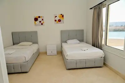 two beds in a room with a window at 6 Bedroom Villa in El-Gouna 38 in Hurghada