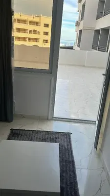 an open door to a balcony with a view of a building at Wonderful sea view studio in Hurghada
