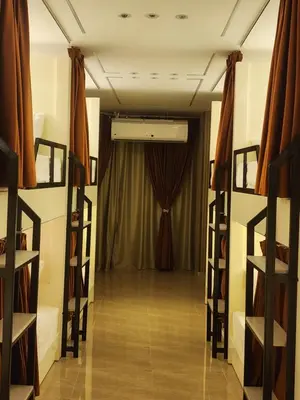 a room with a curtain and a stage with bunk beds at Hana Stay Hostel in Luxor
