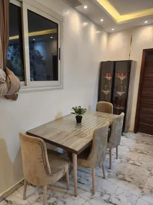 a dining room with a wooden table and chairs at Hana Stay Hostel in Luxor