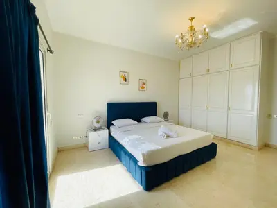 a bedroom with a blue bed and a chandelier at Luxury villa in gouna in Hurghada