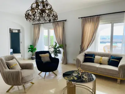 a living room with a couch and chairs and a chandelier at Luxury villa in gouna in El Gouna