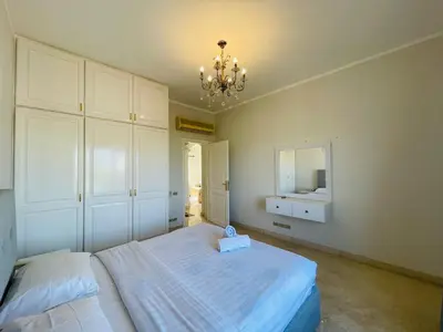 a bedroom with a bed and a mirror and a chandelier at Luxury villa in gouna in El Gouna
