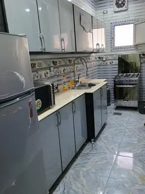 a kitchen with white cabinets and a stainless steel refrigerator at Families only in Al ‘Izbah wa al ‘Arab