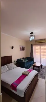 a bedroom with a large bed and a couch at Florenza in Hurghada
