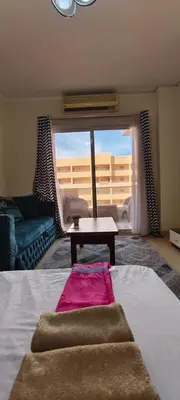 a living room with a bed and a large window at Florenza in Hurghada