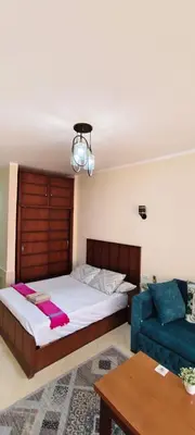 a bedroom with a bed and a blue couch at Florenza in Hurghada