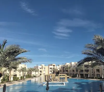 a large swimming pool with palm trees and buildings at Stylish Gouna Mangroovy Retreat in Hurghada