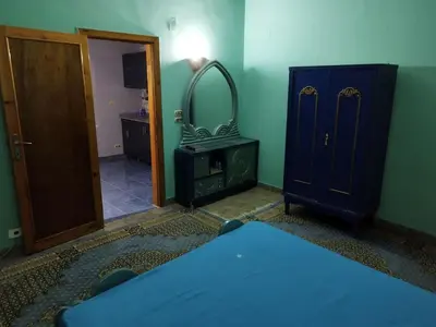 a room with a bed and a dresser and a mirror at Gabawy Garden in ‘Ezbet Abu Ḥabashi