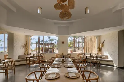 a dining room with tables and chairs and windows at MGM Wellness Retreat in Aswan