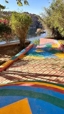 a painting of a river with a rainbow on a sidewalk at Cataract Nile View Rooms in Shellal