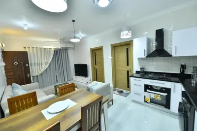a kitchen and living room with a table and a couch at Villa Luna Simone in Al Karnak