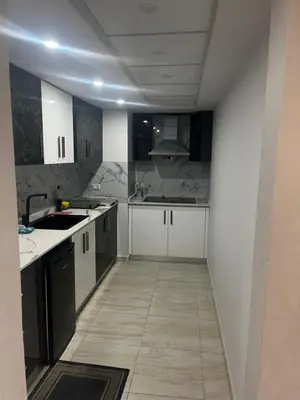 a kitchen with white cabinets and a tile floor at Scandic sea view in Hurghada