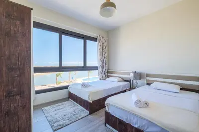 two beds in a room with a view of the ocean at Brand New Shedwan Spacious 1Bdr in Hurghada