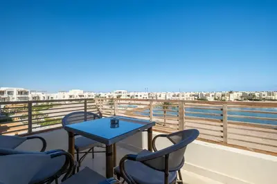 a balcony with a table and chairs and the ocean at Brand New Shedwan Spacious 1Bdr in Hurghada