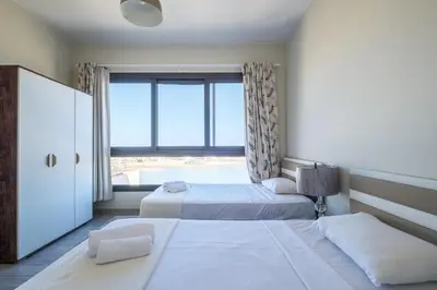 two beds in a room with a large window at Brand New Shedwan Spacious 1Bdr in Hurghada