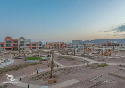 a park with a playground and buildings in the background at Sophisticated 1BR 1,5 Bath Duplex - Kamaran El Gouna, Pool View & Access in Hurghada