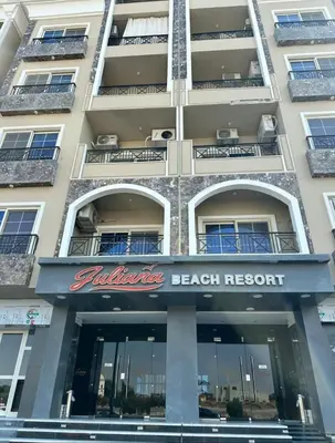 a building with a beach resort sign on it at Seaview 2 Bedroom Private Deluxe Condo at Juliana Beach Resort B2-09 in Hurghada