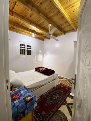 a bedroom with two beds in a room with wooden ceilings at Ammar Guest House in Luxor
