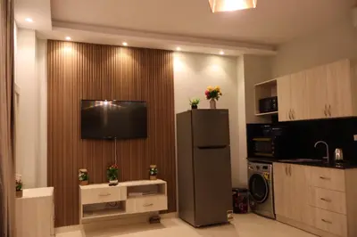 a kitchen with a refrigerator and a television on a wall at Cosy studio Florenza khamsin in hurghada in Hurghada