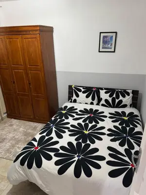 a bedroom with a bed with a black and white comforter at Modernes Komfort mit Smart TV & Power W-LAN, Strandnähe in Hurghada in Hurghada