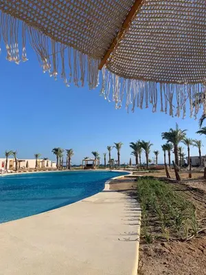 a walkway next to a beach with palm trees at Somabay-Mesca - Relaxing Ground Floor in Hurghada