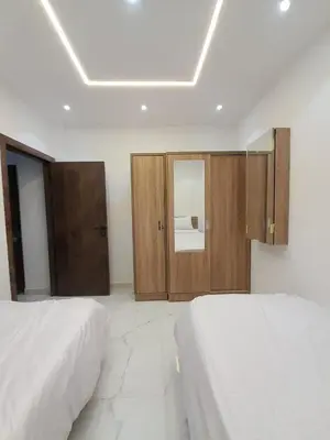 a bedroom with two beds and a cabinet with a mirror at Adler-Hurghada Holiday apartment sea view rooftop pool 80m to beach in Hurghada