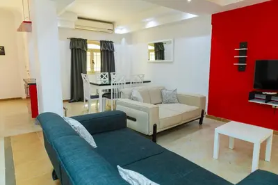 a living room with a blue couch and a red wall at Elaskary in Hurghada