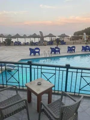 a swimming pool with chairs and a table in front of it at vision suites Arbia Hurghada in Hurghada